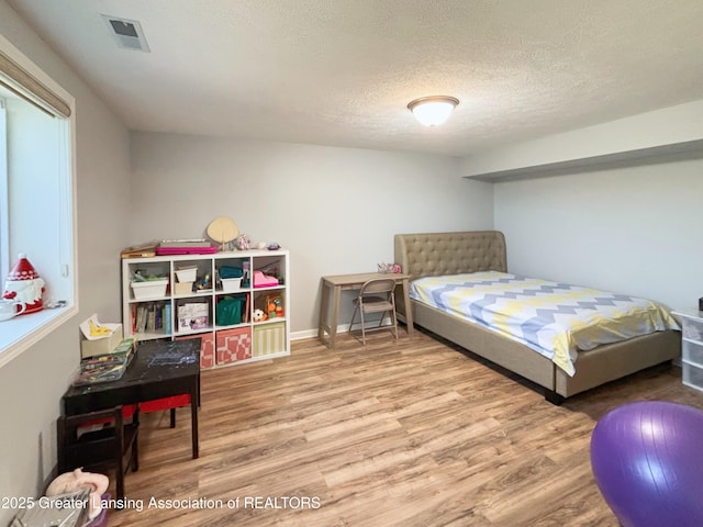 2718 Kittansett Dr, Okemos, MI 48864 - bedroom with wood finished floors, a textured ceiling, and baseboards
