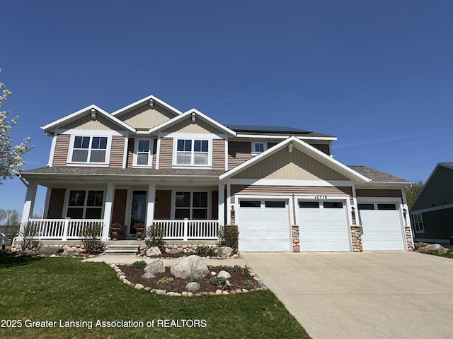 2718 Kittansett Dr, Okemos, MI 48864 - craftsman-style home featuring driveway, an attached garage, solar panels, covered porch, and a front lawn