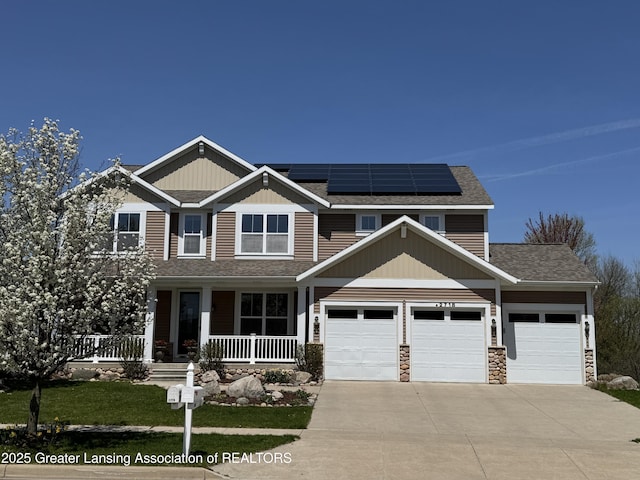 2718 Kittansett Dr, Okemos, MI 48864 - craftsman-style home with a porch, driveway, solar panels, a garage, and roof with shingles
