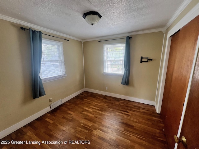 unfurnished bedroom with ornamental molding, visible vents, wood finished floors, and multiple windows