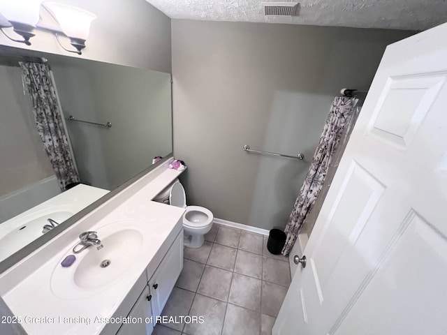 bathroom with tile patterned flooring, toilet, vanity, visible vents, and a textured ceiling