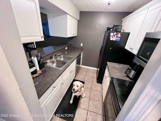 kitchen featuring a textured ceiling, a sink, dishwasher, and white cabinetry