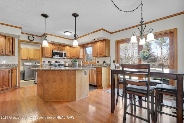 11267 Jarvis Hwy, Dimondale, MI 48821 - kitchen featuring light wood-type flooring, tasteful backsplash, a kitchen island, and stainless steel appliances