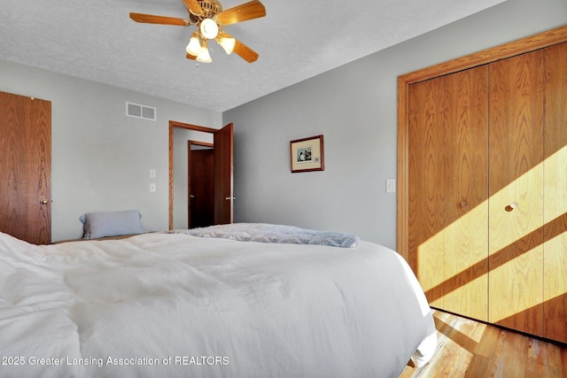 11267 Jarvis Hwy, Dimondale, MI 48821 - bedroom featuring wood finished floors, ceiling fan, a textured ceiling, and visible vents