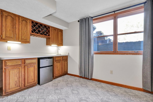 11267 Jarvis Hwy, Dimondale, MI 48821 - kitchen featuring baseboards, light countertops, brown cabinets, and fridge
