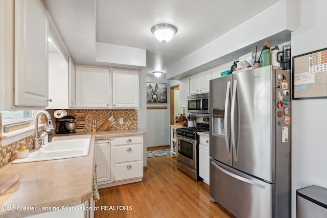 1310 Schavey Rd, Dewitt, MI 48820 - kitchen featuring tasteful backsplash, white cabinets, a sink, stainless steel appliances, and light countertops