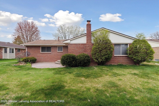 back of property featuring a lawn, a chimney, a patio area, and brick siding