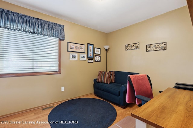 office area with wood finished floors, visible vents, and baseboards