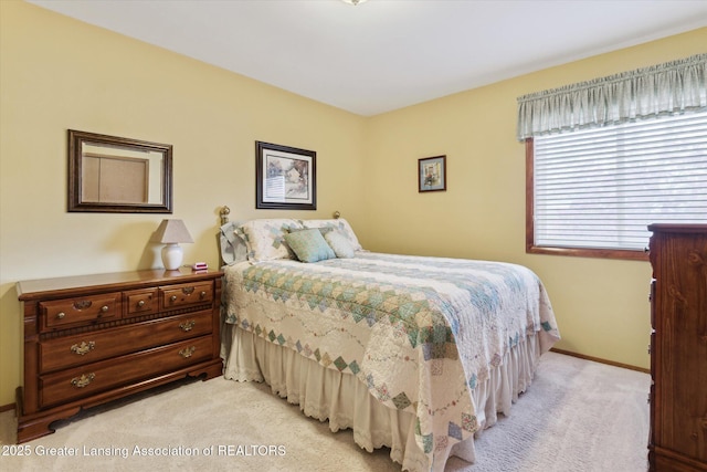 bedroom with baseboards and light carpet