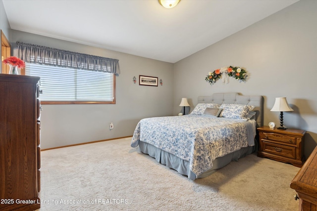 carpeted bedroom with baseboards and vaulted ceiling
