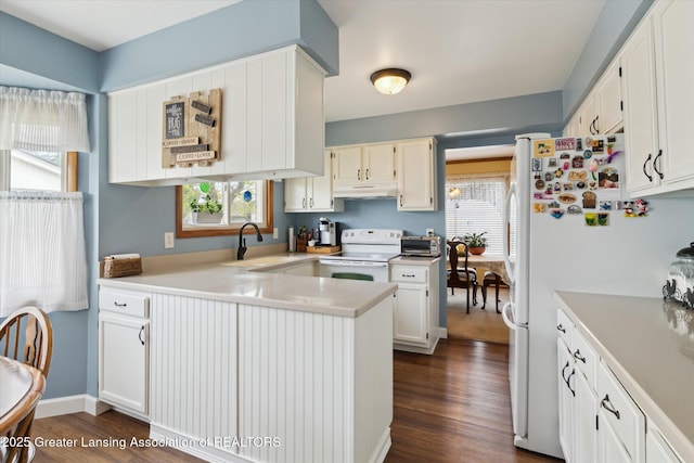 kitchen featuring a peninsula, white appliances, dark wood-style floors, and under cabinet range hood