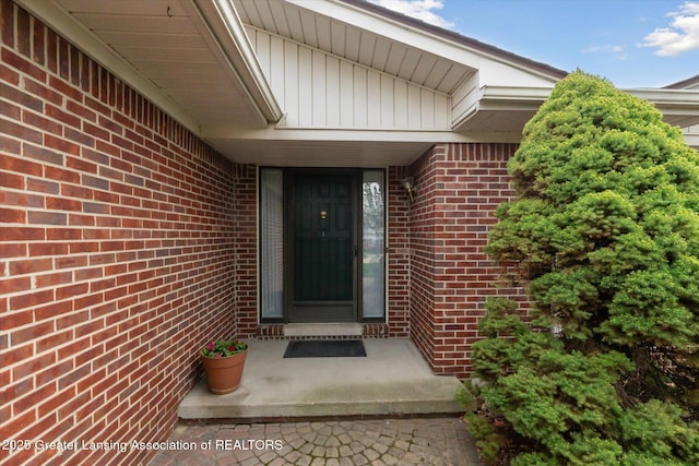 entrance to property featuring brick siding