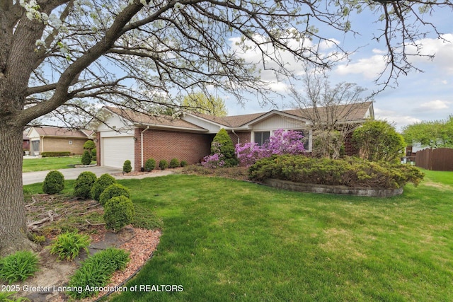 ranch-style home featuring concrete driveway, a front yard, brick siding, and a garage