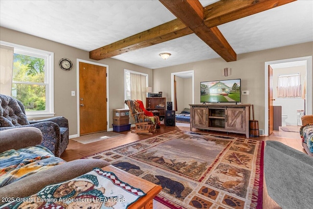 living room with beamed ceiling, baseboards, and wood finished floors