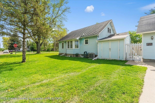 rear view of house featuring central AC unit, a storage shed, and an outbuilding