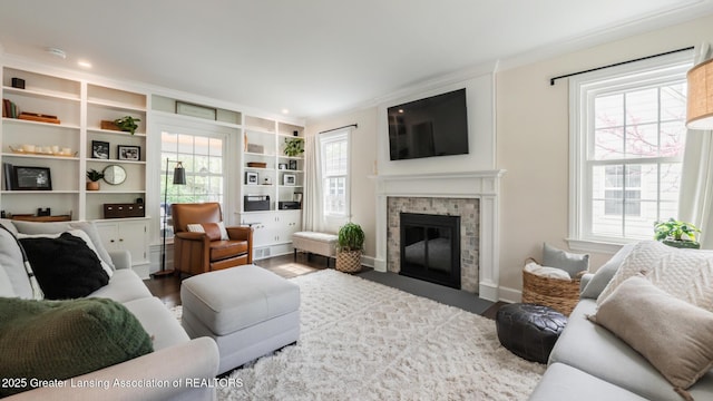 living room featuring baseboards, wood finished floors, a healthy amount of sunlight, and a fireplace