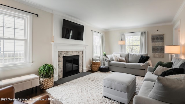 living room featuring dark wood-style flooring, crown molding, baseboards, and a brick fireplace