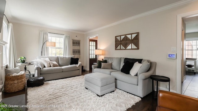 living room with ornamental molding, wood finished floors, and baseboards
