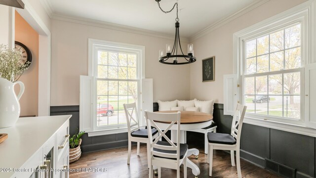 dining space with crown molding, a notable chandelier, visible vents, and dark wood-type flooring