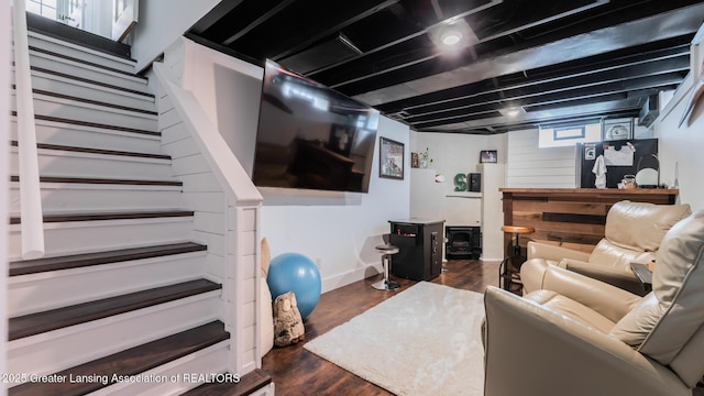 living area with dark wood-style flooring, baseboards, and stairs
