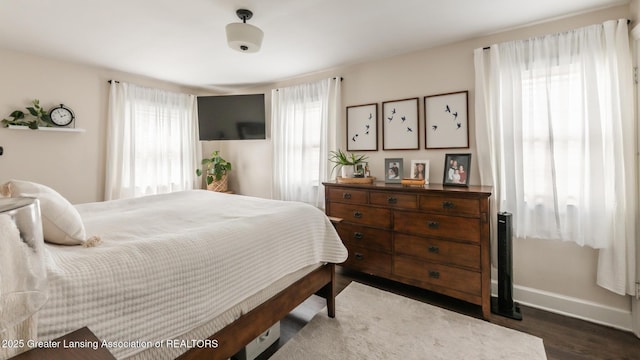 bedroom featuring baseboards and dark wood-type flooring