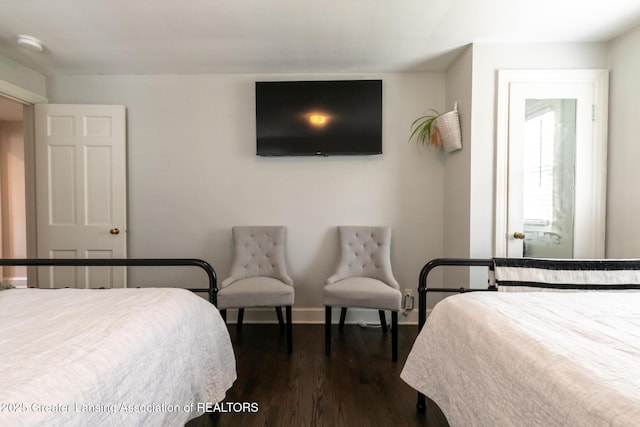 bedroom with dark wood-type flooring and baseboards