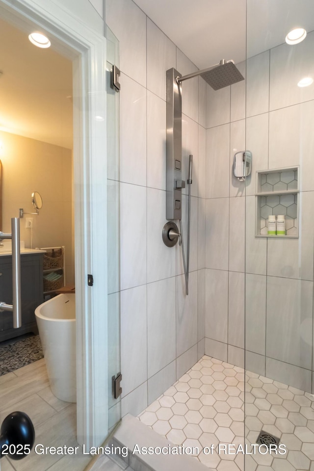 full bathroom with tile patterned floors, recessed lighting, a shower stall, and a sink