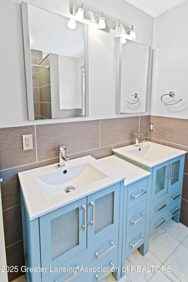 full bathroom featuring a sink, tile walls, tasteful backsplash, and double vanity