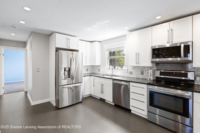 kitchen with white cabinets, appliances with stainless steel finishes, a sink, recessed lighting, and decorative backsplash