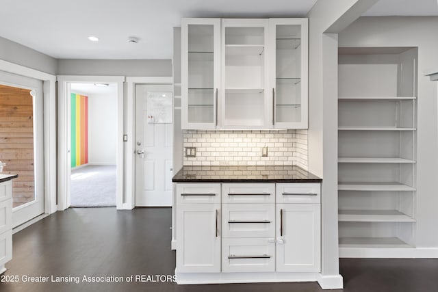 kitchen with glass insert cabinets, recessed lighting, white cabinets, dark wood finished floors, and backsplash