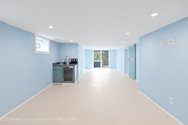 hall with wine cooler, baseboards, recessed lighting, and a sink