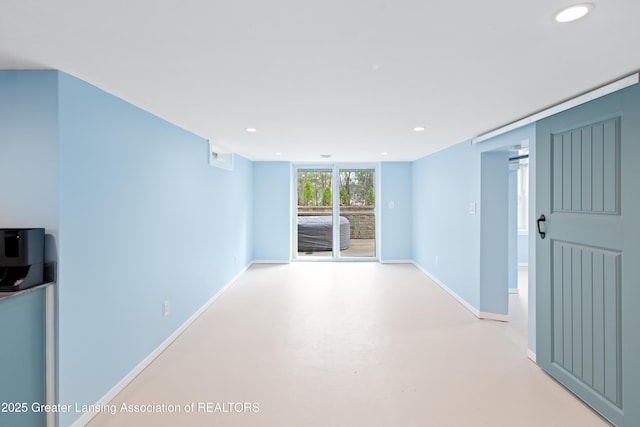unfurnished room featuring recessed lighting, baseboards, and finished concrete flooring