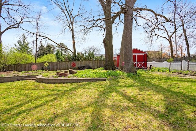 view of yard featuring a barn, an outbuilding, and a fenced backyard