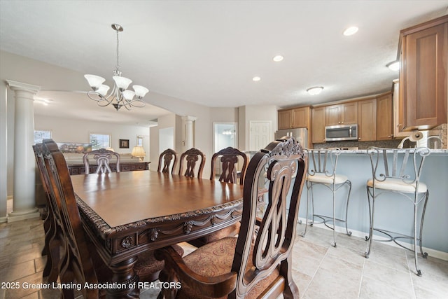 dining room with recessed lighting, a notable chandelier, baseboards, and decorative columns