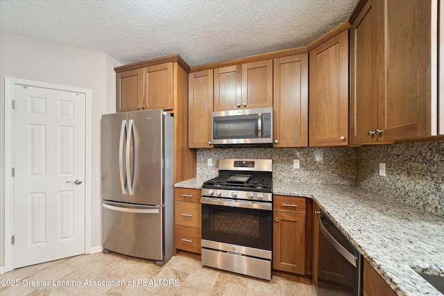 kitchen with stainless steel appliances, decorative backsplash, and brown cabinets