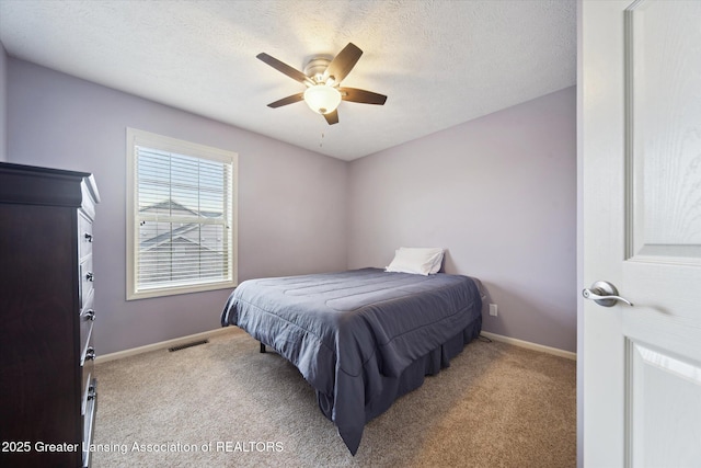 bedroom featuring a textured ceiling, carpet flooring, and baseboards