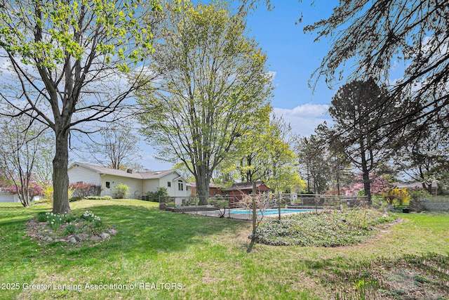 view of yard featuring a fenced in pool and fence