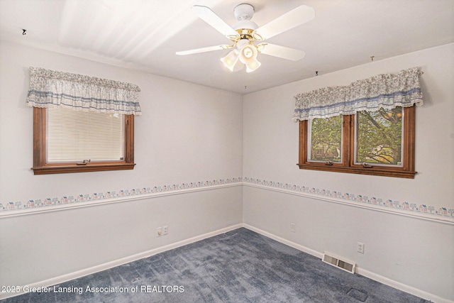 unfurnished room with visible vents, a ceiling fan, baseboards, and dark colored carpet