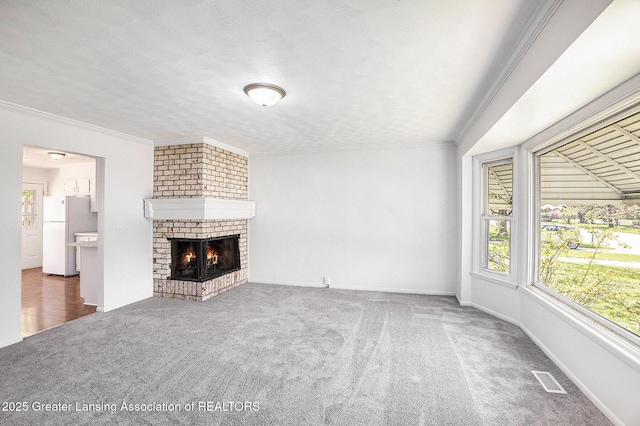 601/603 Farmstead Ln, Lansing, MI 48917 - unfurnished living room featuring carpet flooring, ornamental molding, a fireplace, and baseboards