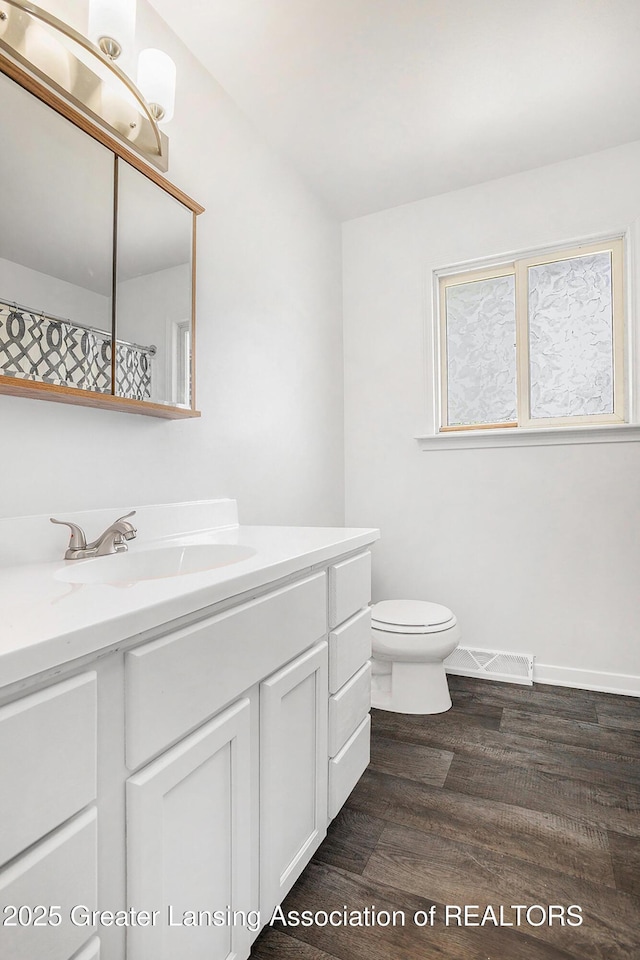 601/603 Farmstead Ln, Lansing, MI 48917 - bathroom featuring wood finished floors, toilet, vanity, and baseboards