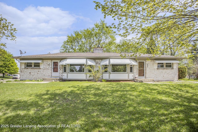 601/603 Farmstead Ln, Lansing, MI 48917 - back of property featuring entry steps, brick siding, a chimney, and a lawn