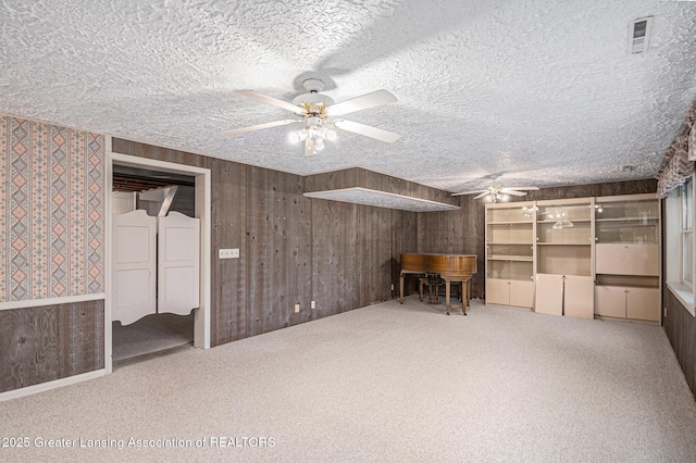 6528 Old River Trl, Lansing, MI 48917 - additional living space with carpet flooring, wooden walls, ceiling fan, and a textured ceiling
