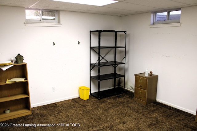 below grade area featuring baseboards, plenty of natural light, and carpet flooring