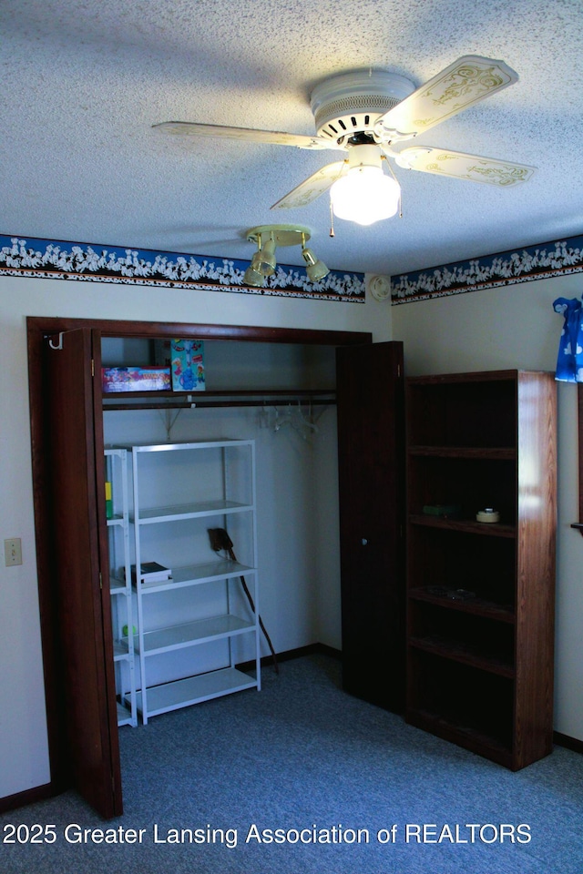 unfurnished bedroom with carpet flooring, a textured ceiling, and a ceiling fan