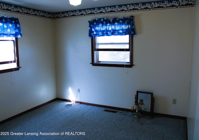 unfurnished room featuring baseboards, carpet, and visible vents