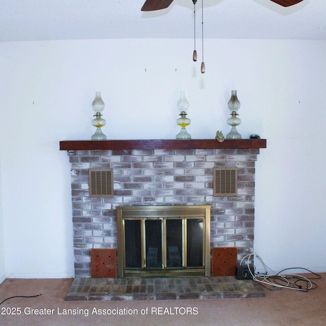 details with a brick fireplace, a ceiling fan, visible vents, and carpet