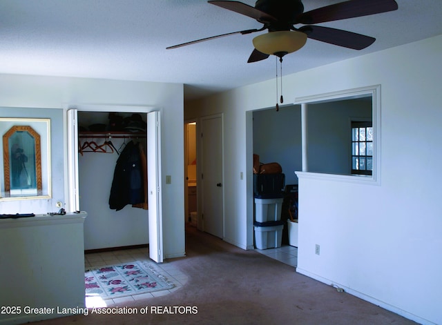 unfurnished bedroom featuring ceiling fan, carpet, and a closet
