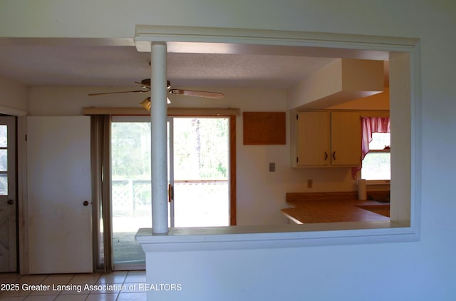 kitchen featuring a ceiling fan, light tile patterned flooring, a wealth of natural light, and a peninsula