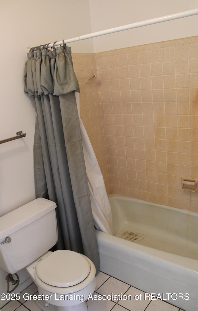 full bath with toilet, tile patterned floors, and shower / tub combo