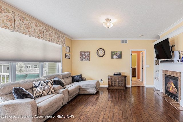 living area featuring a fireplace, visible vents, crown molding, and dark wood finished floors